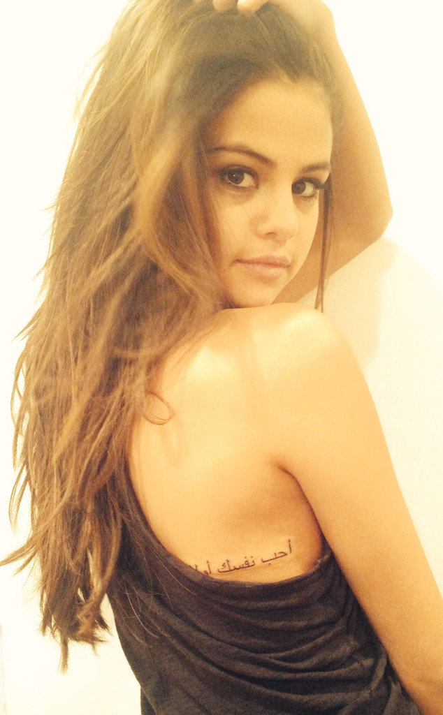 Pictures of Selena Gomez's new tattoo have come out and apparently she absolutely adores her new ink. The tattoo which is in Arabic means 'Love Yourself First' after being translated it means love yourself. The tat is in on the right side of the middle of her back. She reportedly had the ink for over a month now. To check out the 'Come and Get It' singer's new tat CLICK HERE!